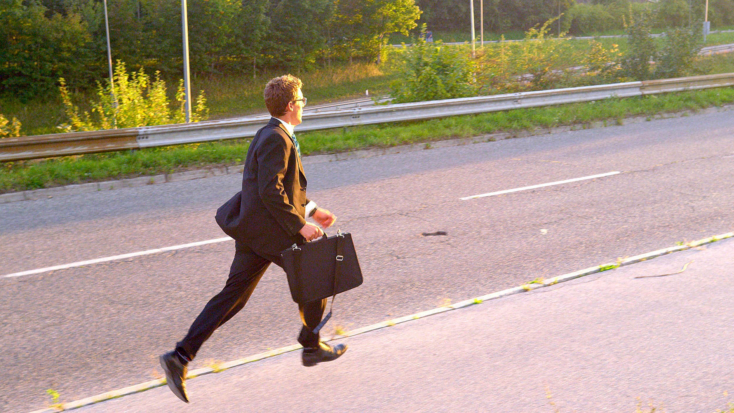 Office dude with briefcase chasing cars