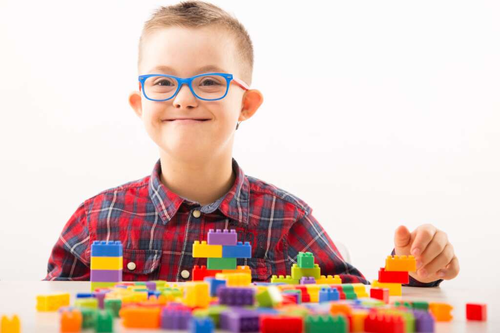 Enfants-de-dieu.  Child with Down syndrome during occupational therapy play.